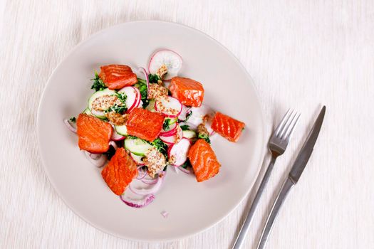 Broiled salmon with radish and spinach, served on white plate. View from above, top studio shot