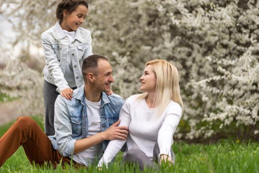 Happy male and female playing with child outside, spring
