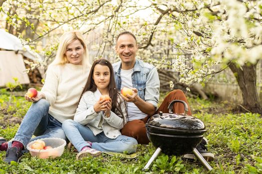 smiling parent grilling meat with daughter on camping.