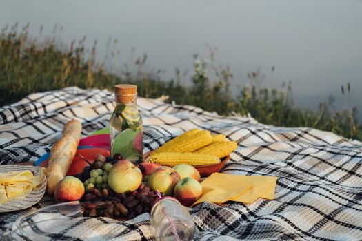 Picnic Set, Fruits and Lemonade Laid Up on the Plaid by River at Sunset