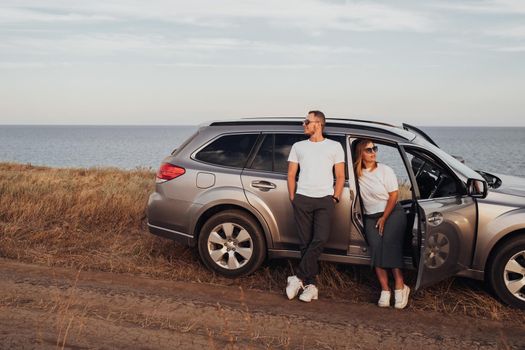 Man and Woman Enjoying Their Road Trip on SUV Car, Young Couple on Vacation, Travel to Sea