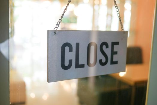 closed sign hanging on door of cafe