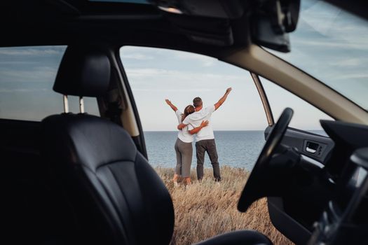 View From Car Interior, Young Couple on Road Trip, Man and Woman Embracing on Sea Background
