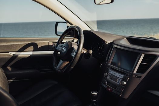 ODESA, Ukraine - August 26 2020: CloseUp View of Interior and Steering Wheel of Subaru Outback, Sea on the Background