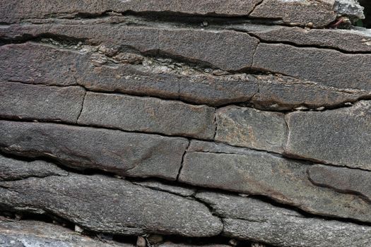 Close-up texture of a natural river bank stone wall in a mountain forest in northern Thailand. Stone and ecology concept.