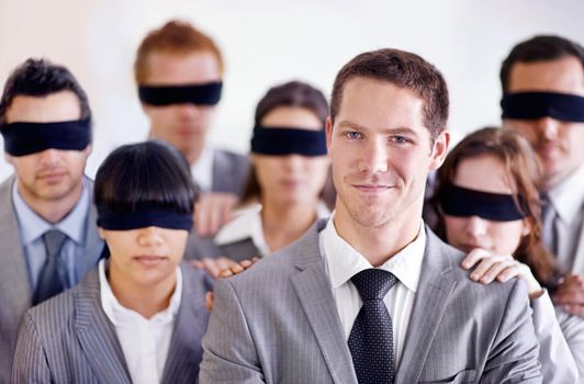 A young businessman standing in front of a group of blindfolded businesspeople.