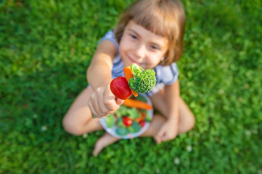 child eats vegetables broccoli and carrots. Selective focus.