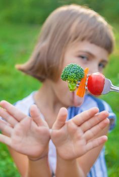 child eats vegetables broccoli and carrots. Selective focus.