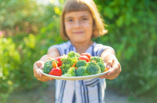 child eats vegetables broccoli and carrots. Selective focus.