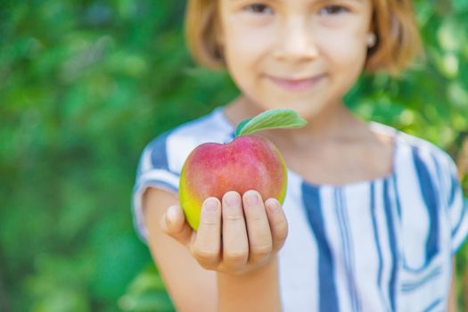 child with an apple in the garden. Selective focus.