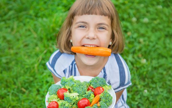 child eats vegetables broccoli and carrots. Selective focus.