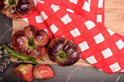 Fresh tomatoes in a plate on a dark background. Harvesting tomatoes. Top view