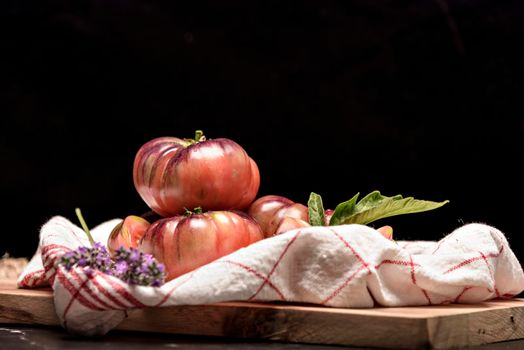 Beautiful fresh tiger tomatoes on dark background