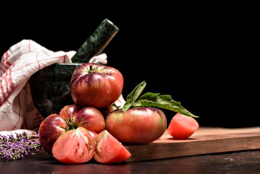 Fresh tomatoes in a plate on a dark background. Harvesting tomatoes. Top view