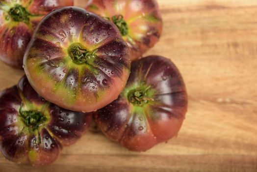 Fresh tomatoes in a plate on a dark background. Harvesting tomatoes. Top view