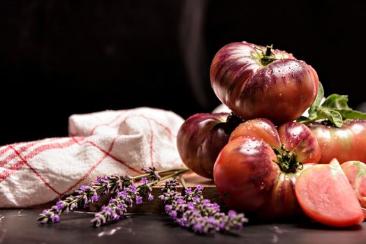 Fresh tomatoes in a plate on a dark background. Harvesting tomatoes. Top view