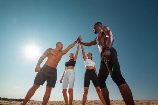 Fitness team outdoors. Sport concept. Group of fit friends athletes are standing on the sky background. Healthy lifestyle.