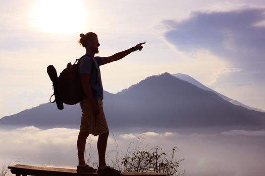 Hiker walking along a mountain path. Sunrise on top of mountain