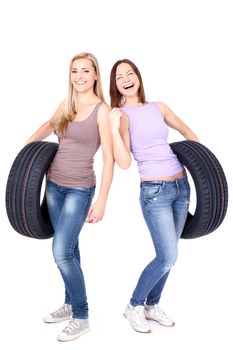 Two women holding car wheels and laughing. Isolated on white.