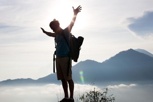 Hiker walking along a mountain path. Sunrise on top of mountain