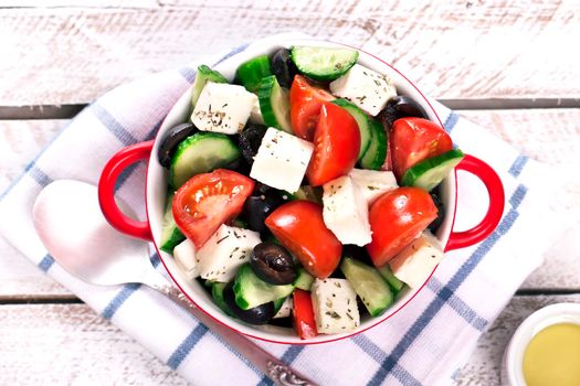 Greek salad in red boul and olive oil - Stock image
