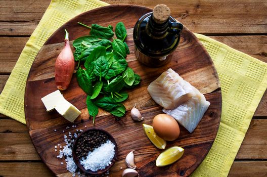 Delicious sea fish fillet with fresh healthy herbs,vegetables, oil and spices - Stock image