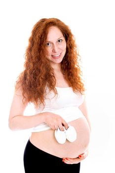 Pregnant woman holding a beautiful baby shoes isolated on white