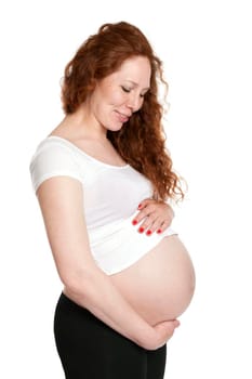 Pregnant woman hugging her belly and smiling. Isolated on white.