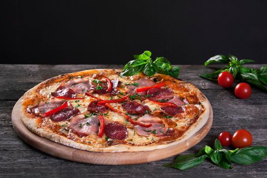 Delicious fresh Pepperoni pizza with salami , bacon , red pepper, green onions and cheese on the wooden background. Top view.