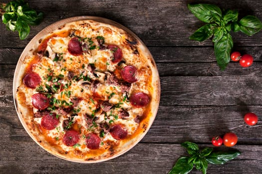 Pepperoni Pizza with salami, mushrooms , meat , beef, cheese and green onions on the wooden background. Top view.