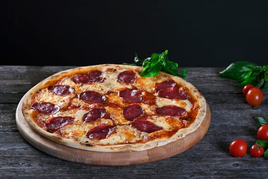 Delicious fresh Pepperoni pizza with salami and cheese on the wooden background. Top view.