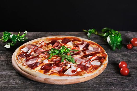 Delicious fresh Pizza with bacon and tomato paste on the wooden background. Top view.