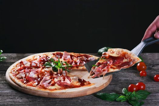 Delicious fresh Pizza with bacon and tomato paste on the wooden background. Top view.