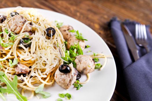 Pasta and meatballs with anchovies and olives. Top view