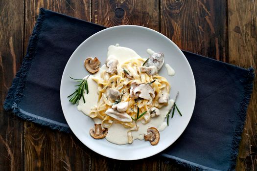 Tagliatelle vegetarian Pasta Dish with Mushrooms on the wooden background - Stock image