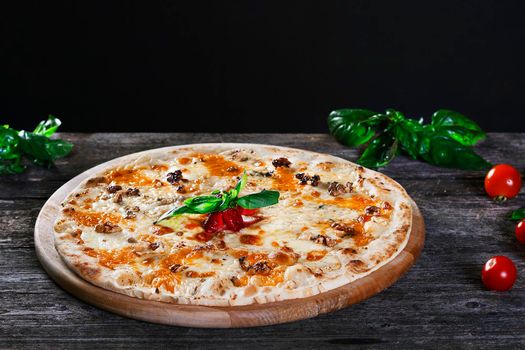 Delicious fresh Pizza with walnuts, cheese and tomato paste on the wooden background. Top view.