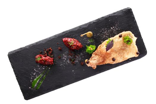 Molecular modern cuisine. Chips Pigskin with tartare or carpaccio of beef. Stock image. Isolated on white.