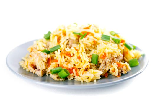 Fragrant Pilau Pulav pilaf pilaf, fried rice with meat and vegetables on a grey plate. Isolated on white. Macro.