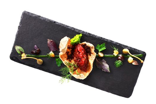 Molecular modern cuisine. Chips Pigskin with tartare or carpaccio of beef. Stock image. Isolated on white.