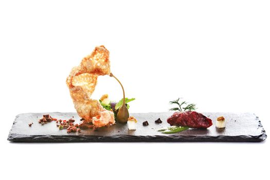 Molecular modern cuisine. Chips Pigskin with tartare or carpaccio of beef. Stock image. Isolated on white.