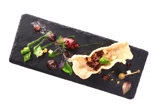 Molecular modern cuisine. Chips Pigskin with tartare or carpaccio of beef. Stock image. Isolated on white.