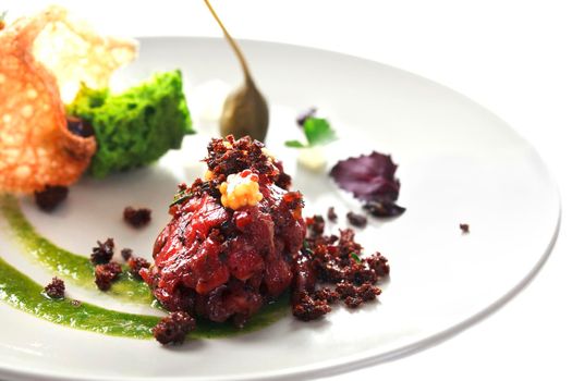 Molecular modern cuisine. Chips Pigskin with tartare or carpaccio of beef. Stock image. Isolated on white.