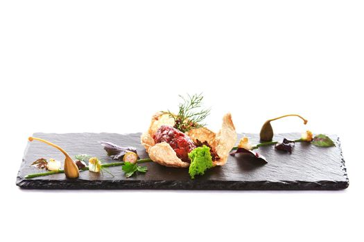 Molecular modern cuisine. Chips Pigskin with tartare or carpaccio of beef. Stock image. Isolated on white.