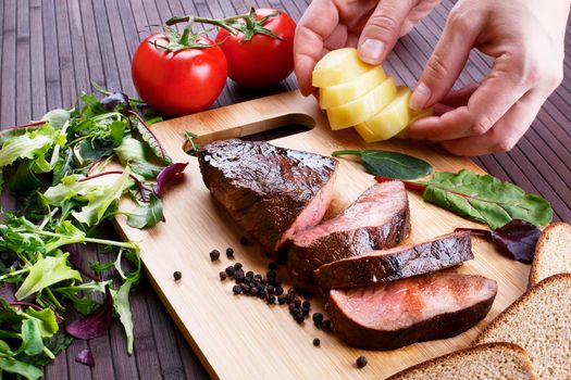 Close-up of Medium Rare Roast Beef with Fresh Herbs and Vegetables