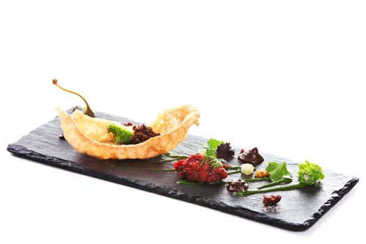 Molecular modern cuisine. Chips Pigskin with tartare or carpaccio of beef. Stock image. Isolated on white.