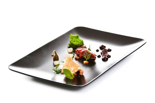 Molecular modern cuisine. Chips Pigskin with tartare or carpaccio of beef. Stock image. Isolated on white.