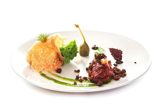 Molecular modern cuisine. Chips Pigskin with tartare or carpaccio of beef. Stock image. Isolated on white.