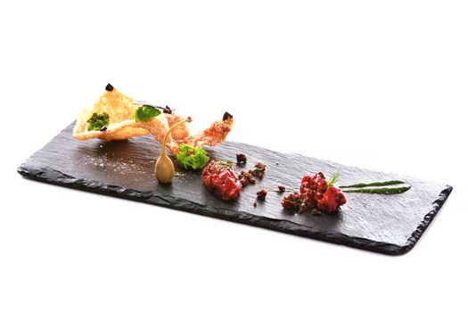 Molecular modern cuisine. Chips Pigskin with tartare or carpaccio of beef. Stock image. Isolated on white.