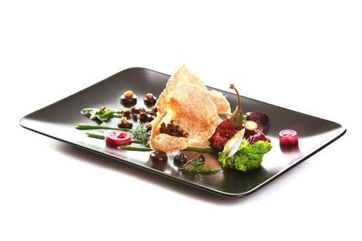 Molecular modern cuisine. Chips Pigskin with tartare or carpaccio of beef. Stock image. Isolated on white.