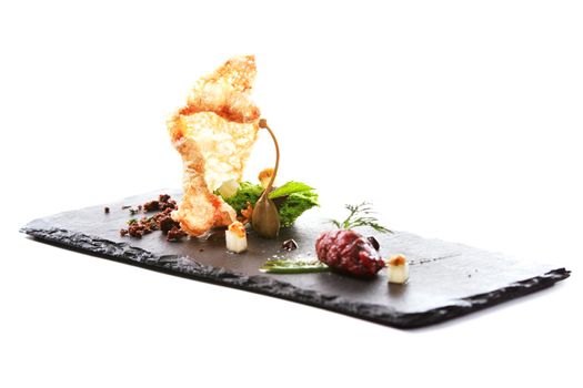 Molecular modern cuisine. Chips Pigskin with tartare or carpaccio of beef. Stock image. Isolated on white.